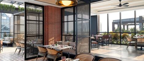 A modern dining area with a wooden table set for two, surrounded by wicker chairs.