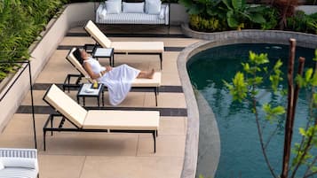 Una piscina al aire libre, camas de piscina gratis, sombrillas