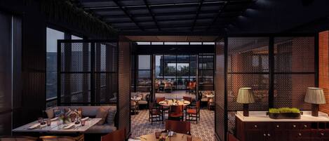 A modern dining area with a high ceiling, open space, and a view of the cityscape.