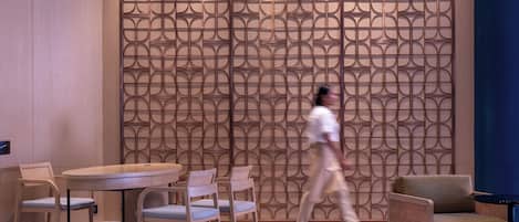 Un interior moderno con una pared estampada, una mesa redonda y varias sillas.