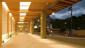 A covered walkway leading to a building entrance with a glass door, surrounded by pillars and a tiled floor. - Nakanobo Zuien - Adults Only (Kobe)