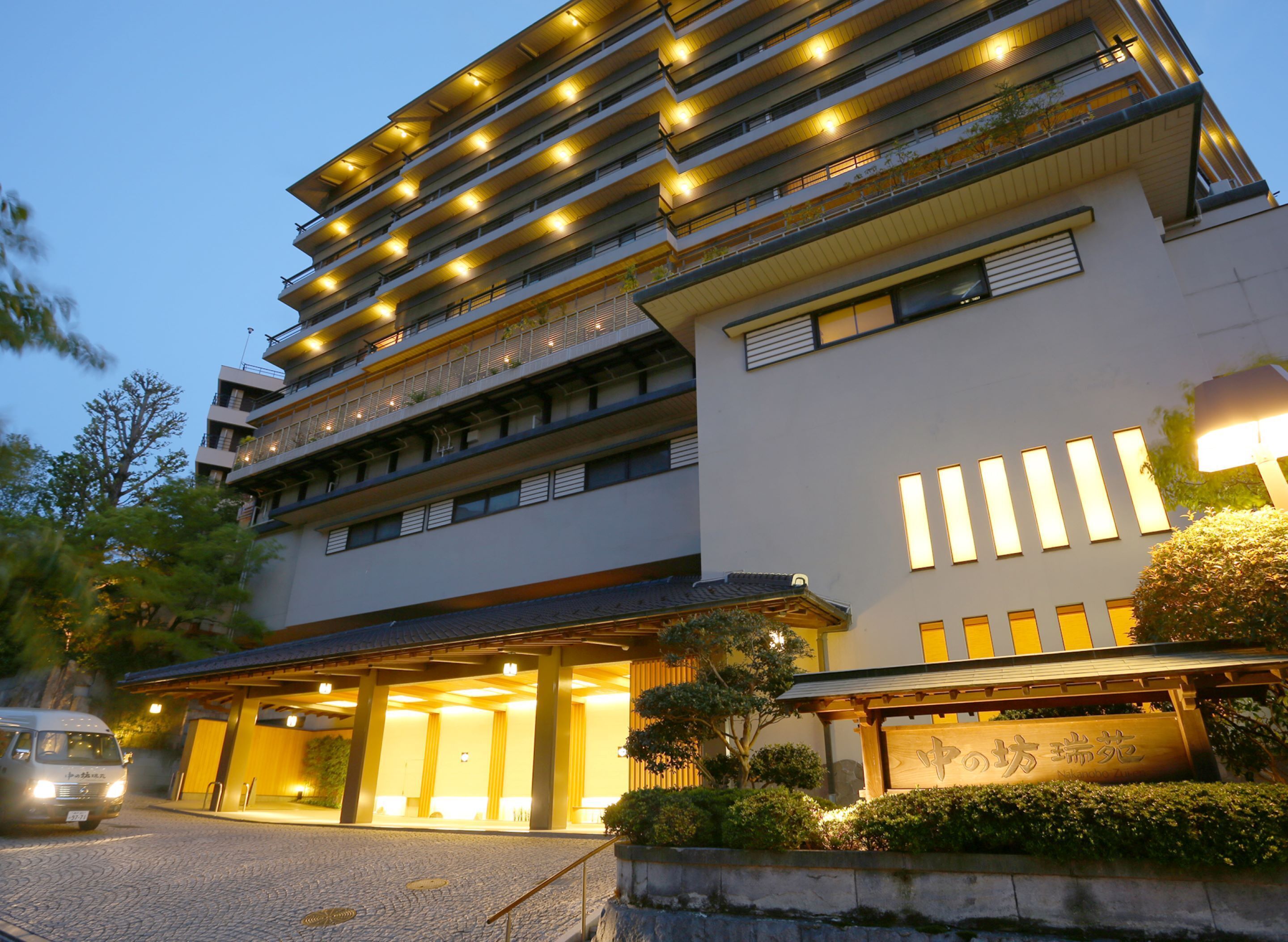 A multi-story hotel with a modern design, featuring a covered entrance and a well-lit facade.