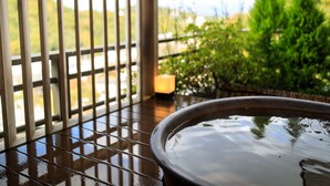 A hot tub with a view of a garden and hills in the background. - Nakanobo Zuien - Adults Only (Kobe)