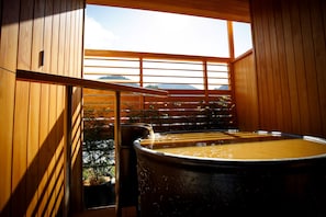 A wooden sauna with a large barrel bath, a window with a view of mountains, and a wooden railing. - Nakanobo Zuien - Adults Only (Kobe)