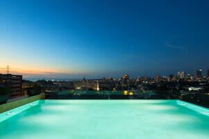 Una piscina al aire libre, sombrillas, tumbonas