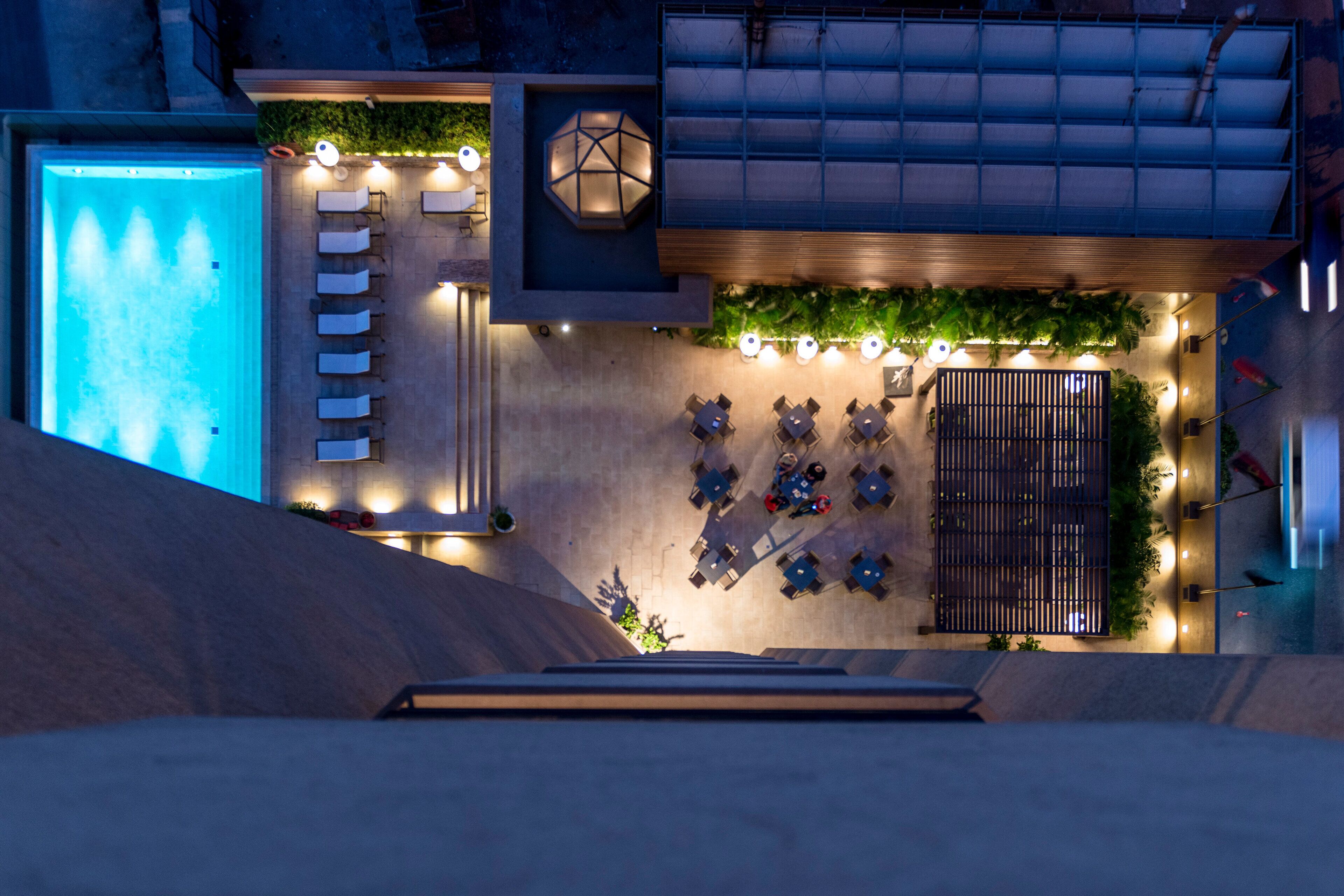 Una piscina al aire libre, sombrillas, sillones reclinables de piscina