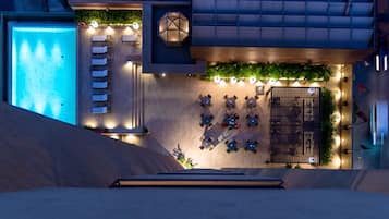Una piscina al aire libre, sombrillas, sillones reclinables de piscina