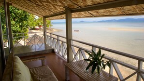 A covered outdoor seating area with a view of the beach. - Milky Bay Resort (Ko Pha-ngan)