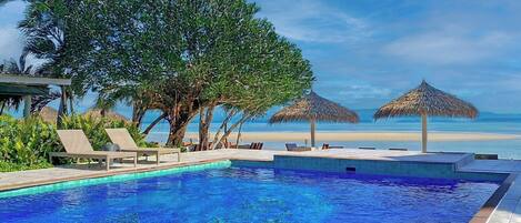 Alberca al aire libre y camastros