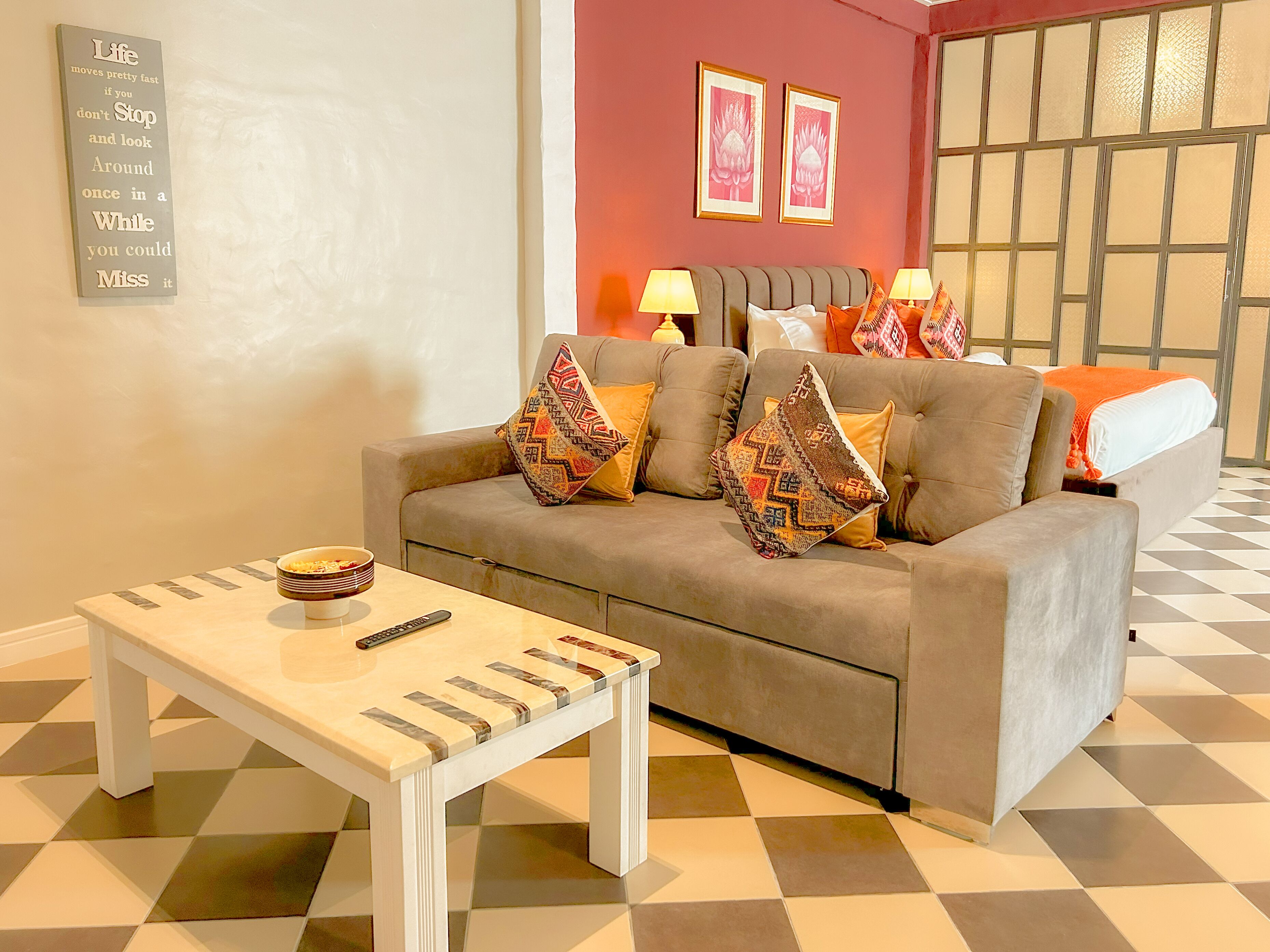 Ein modernes Wohnzimmer mit einer Couch, Kissen, einem Couchtisch und einem an der Wand befestigten Schild.