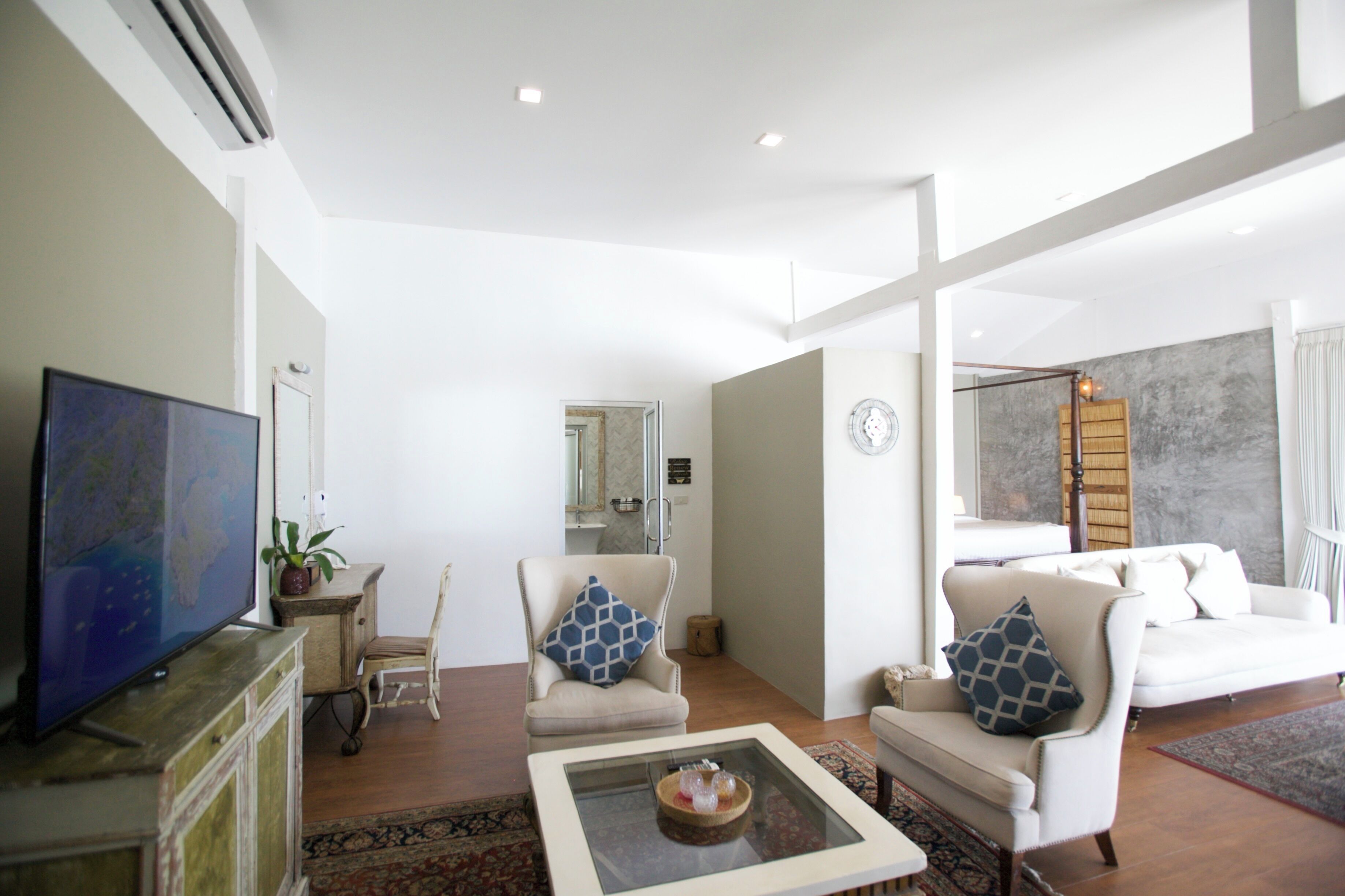 A spacious living room with a flat-screen TV, a coffee table, and a sofa.