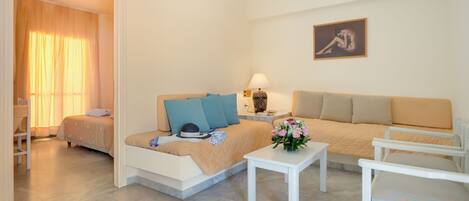A modern bedroom with a bed, a sofa, a small table, and a chair.