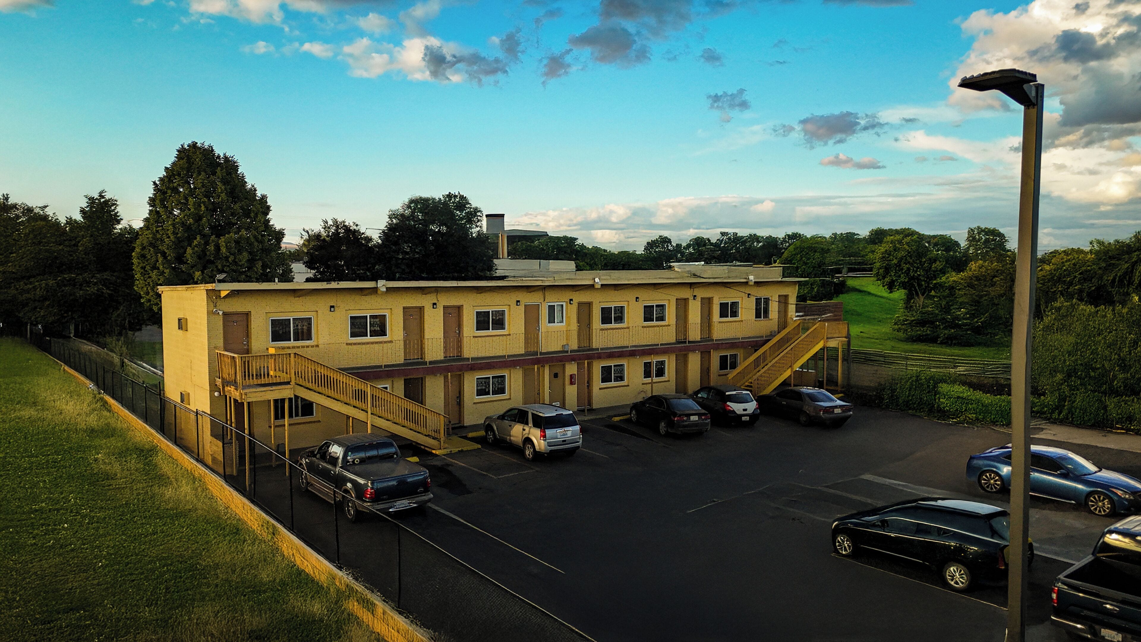 A multi-story building with a parking lot, a staircase, and a streetlight.