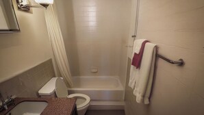 A bathroom with a sink, toilet, bathtub, and a towel rack.