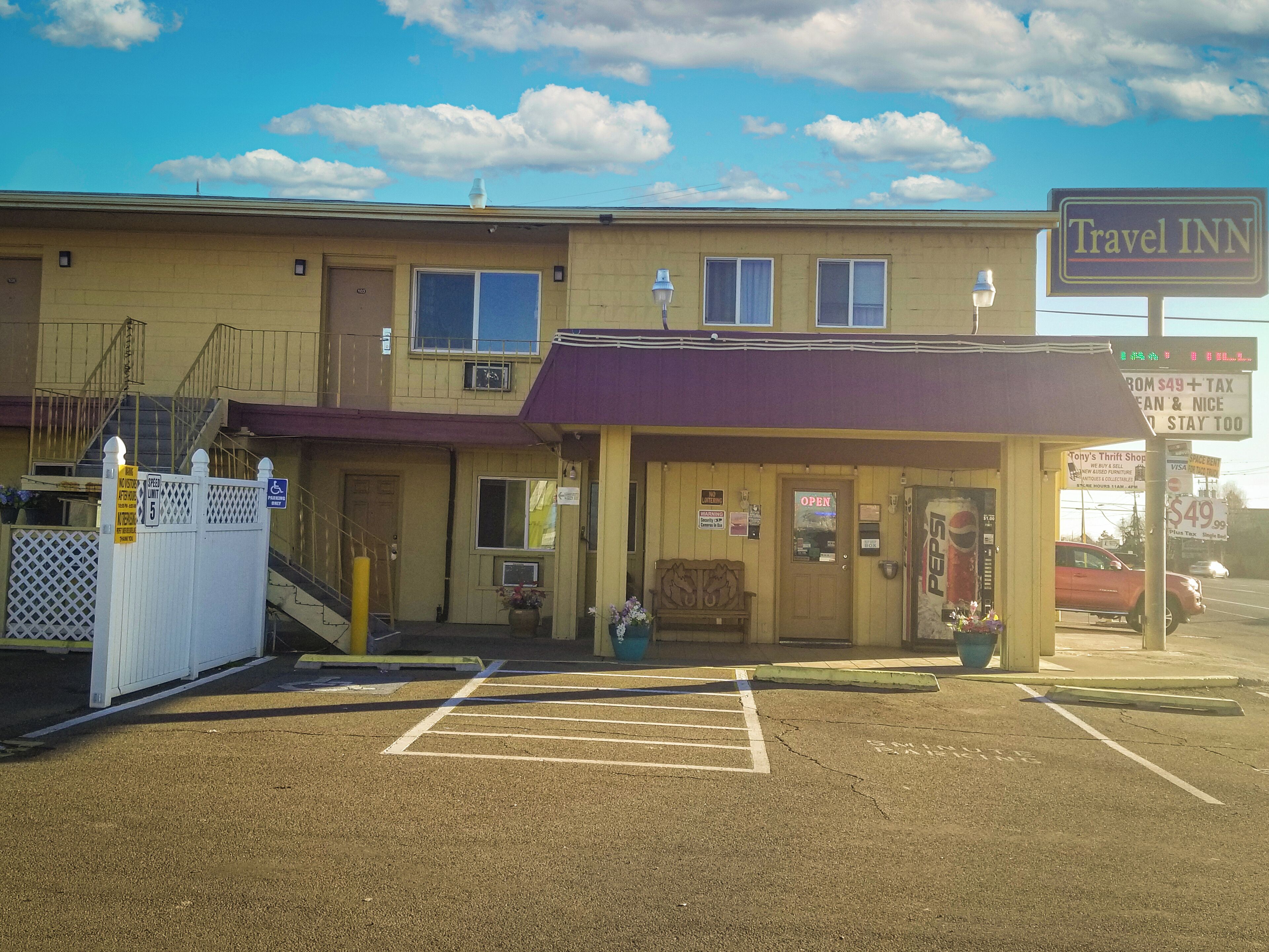 A Travel Inn with a two-story building, a covered parking area, and a visible entrance.