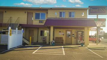 A Travel Inn with a two-story building, a covered parking area, and a visible entrance.