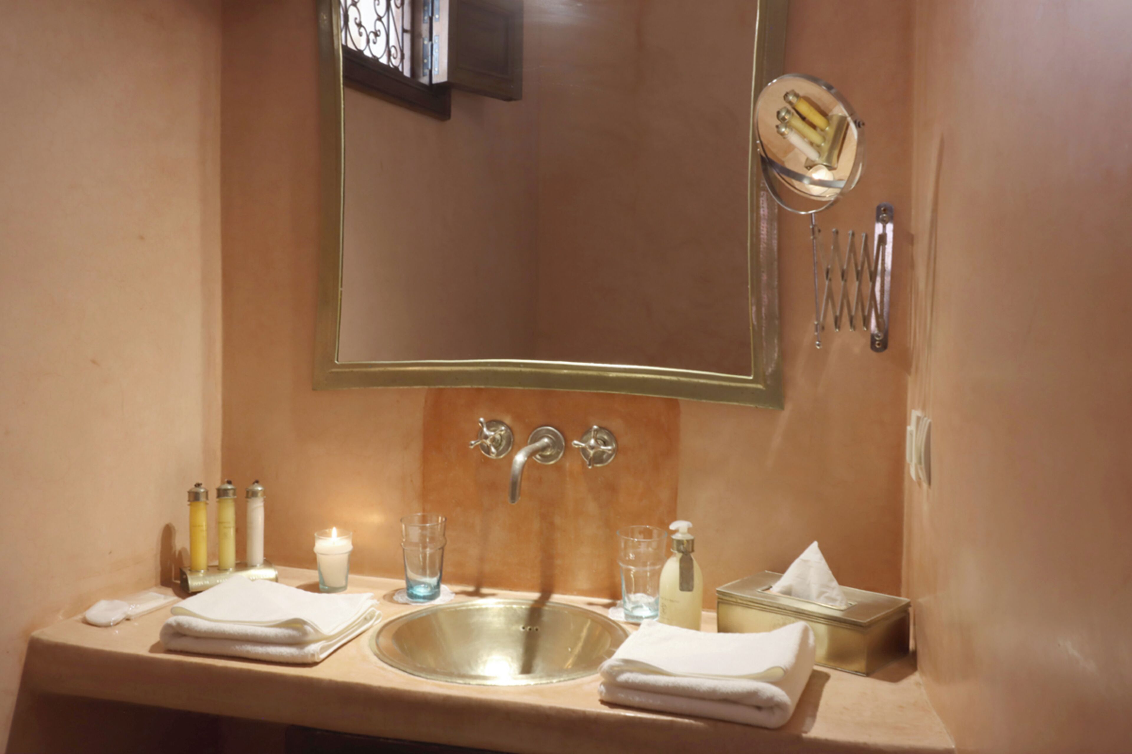 A bathroom with a sink, mirror, and toiletries.