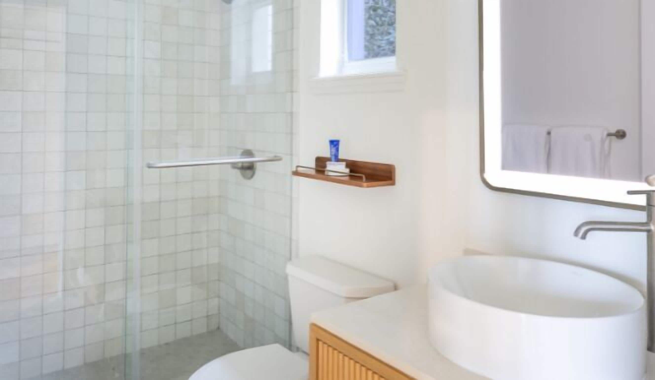 Une salle de bain avec douche, toilettes et lavabo.