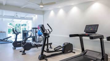 Ein Fitnessstudio mit Laufbändern, Crosstrainern und Rudergeräten.