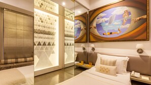 Habitación de hotel con una cama grande, una mesita de noche, un espejo y obras de arte en la pared.