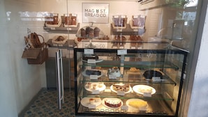 Una vitrina de pastelería con diversos productos horneados y postres.