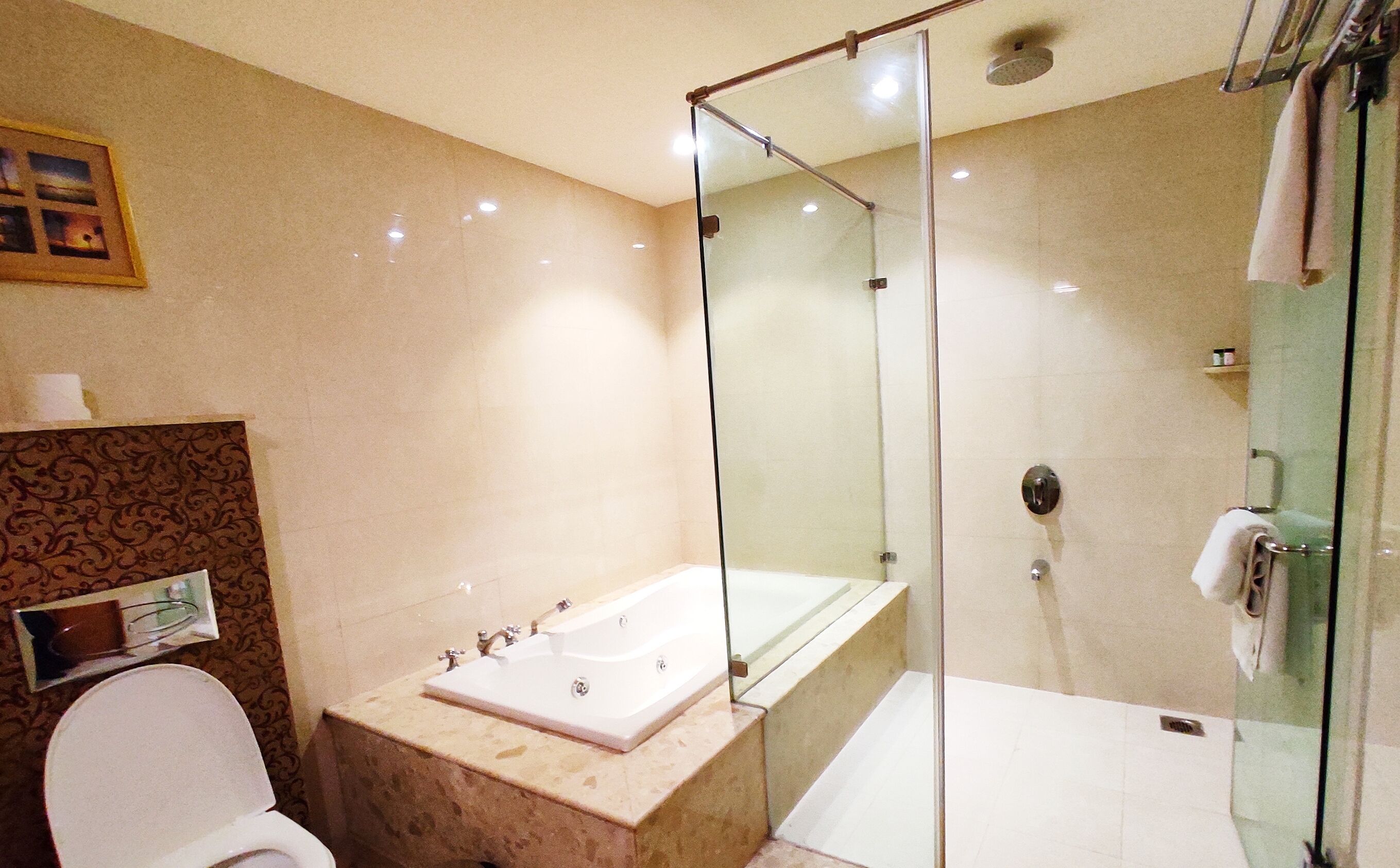 A modern bathroom with a glass-enclosed shower, a standalone bathtub, and a toilet.