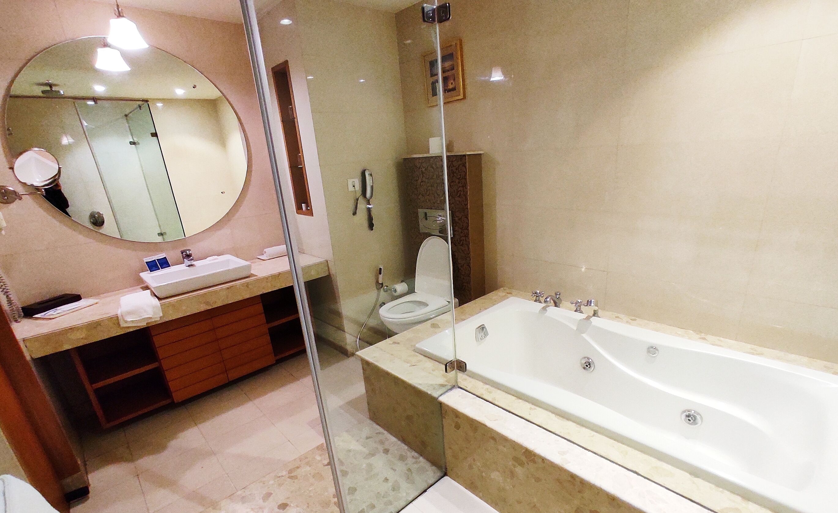 Ein modernes Badezimmer mit einem großen Spiegel, einem Waschbecken, einer Toilette und einer Badewanne.