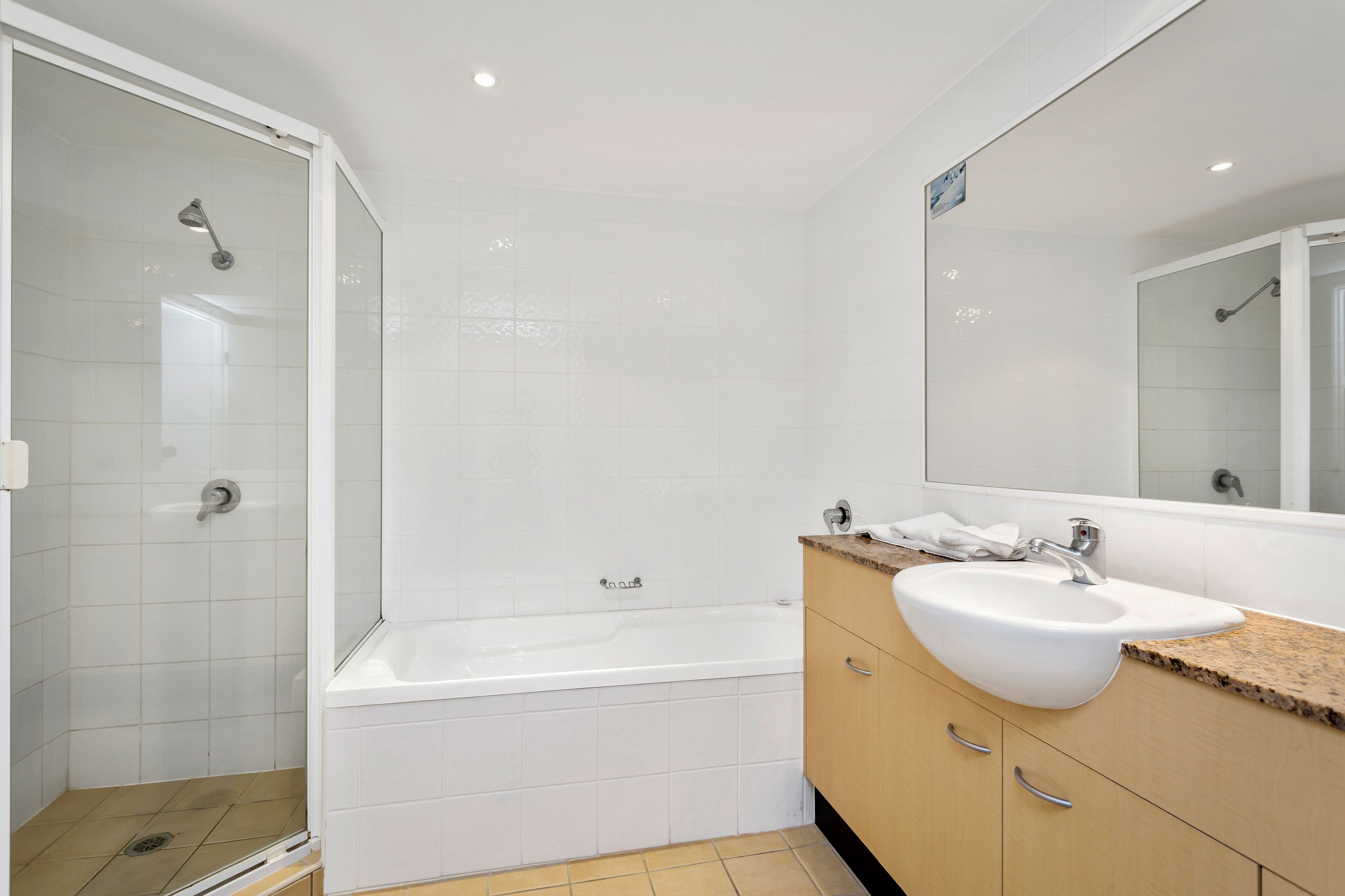 A modern bathroom with a glass-enclosed shower, a freestanding bathtub, and a vanity with a sink.