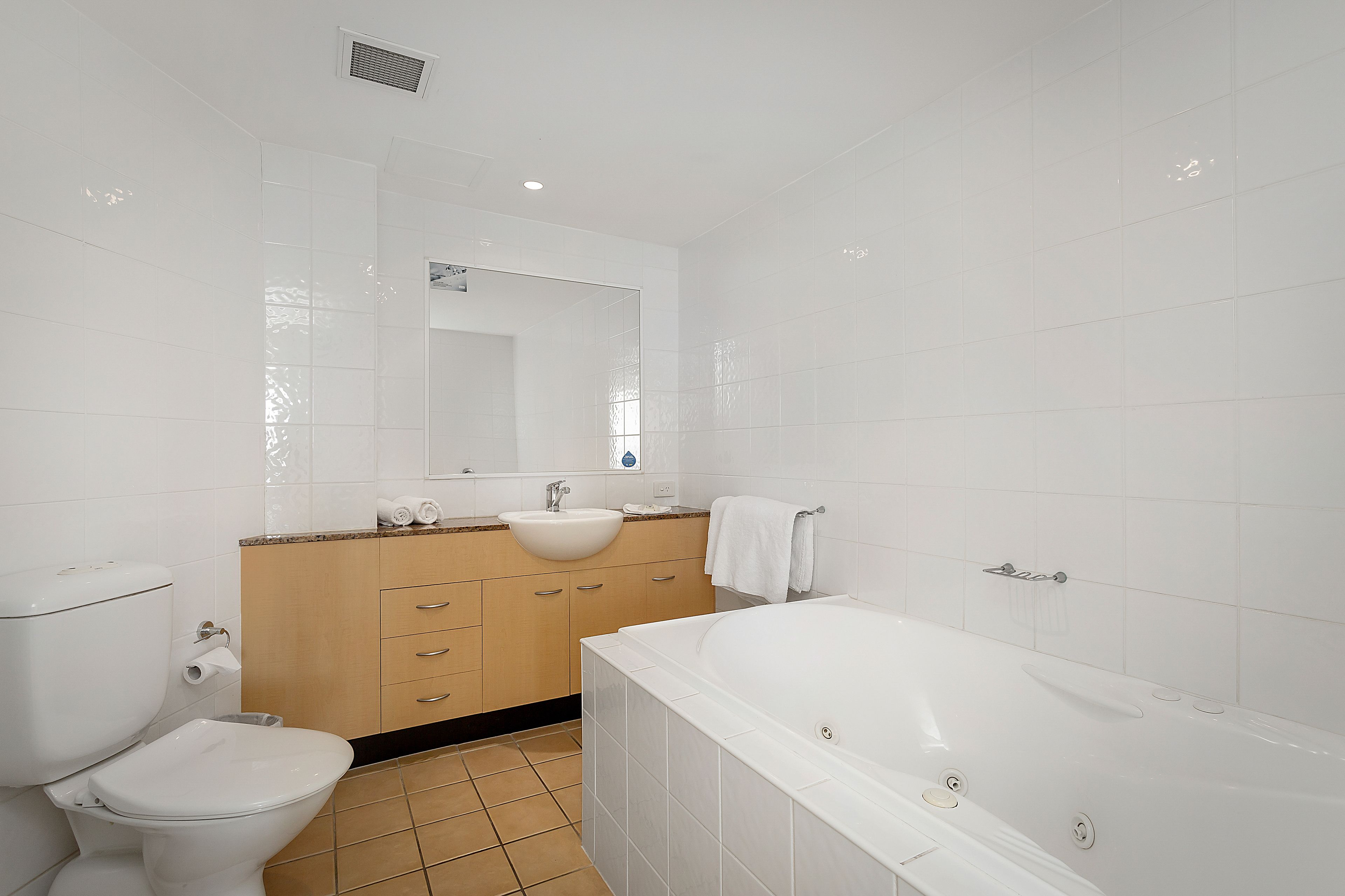 Une salle de bain moderne équipée de toilettes, d’un lavabo, d’un meuble-lavabo et d’une baignoire.