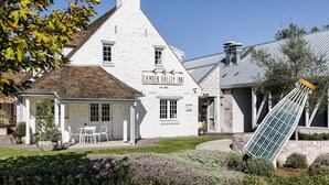 A white building with a sign reading "Camden Valley Inn" and a small outdoor seating area. - Camden Valley Inn (Cawdor)