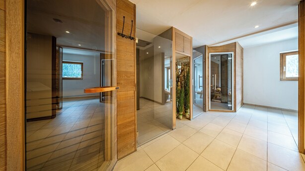 A modern interior with glass doors, wooden accents, and a tiled floor.