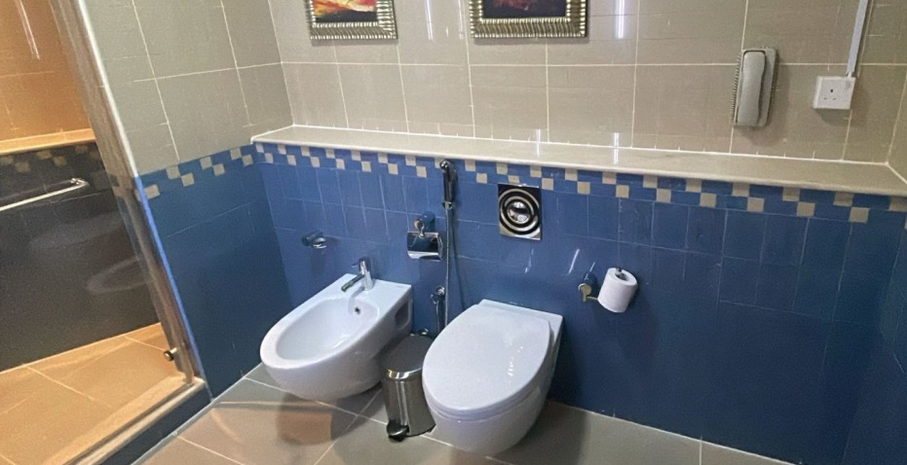A bathroom with two urinals, a toilet, and a shower area.
