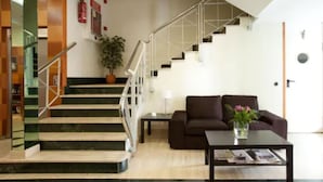Eine moderne Lobby mit Treppe, einer Couch und einem Couchtisch.