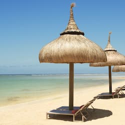 Na praia, areia branca, barracas de praia de cortesia, espreguiçadeiras