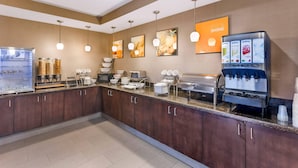 A breakfast bar with a coffee machine, food dispensers, and a refrigerator. - Comfort Suites Blythe (Blythe)