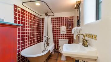 A bathroom with a freestanding bathtub, a sink, and a toilet.