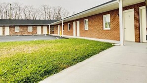 A motel with a covered parking area and a grassy lawn. - Relax Inn Smyrna (Smyrna)