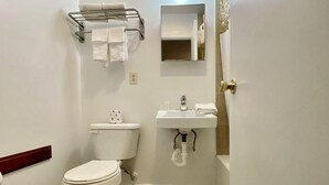 A small, clean bathroom with a toilet, sink, and towel rack. - Relax Inn Smyrna (Smyrna)