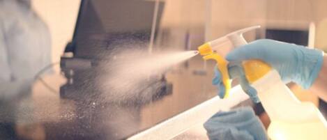 A person cleaning a glass surface with a spray bottle.