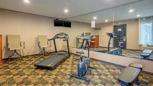 A fitness room with treadmills, an elliptical, and a bench.
