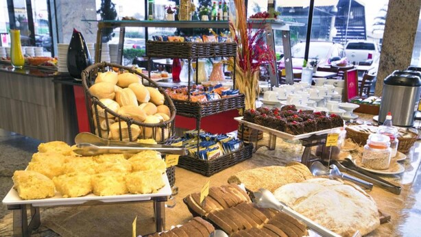 A buffet with various food items including bread, pastries, and desserts.