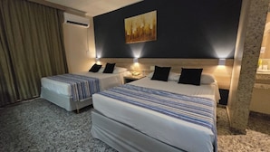 A hotel room with two beds, a large painting on the wall, and an air conditioning unit.