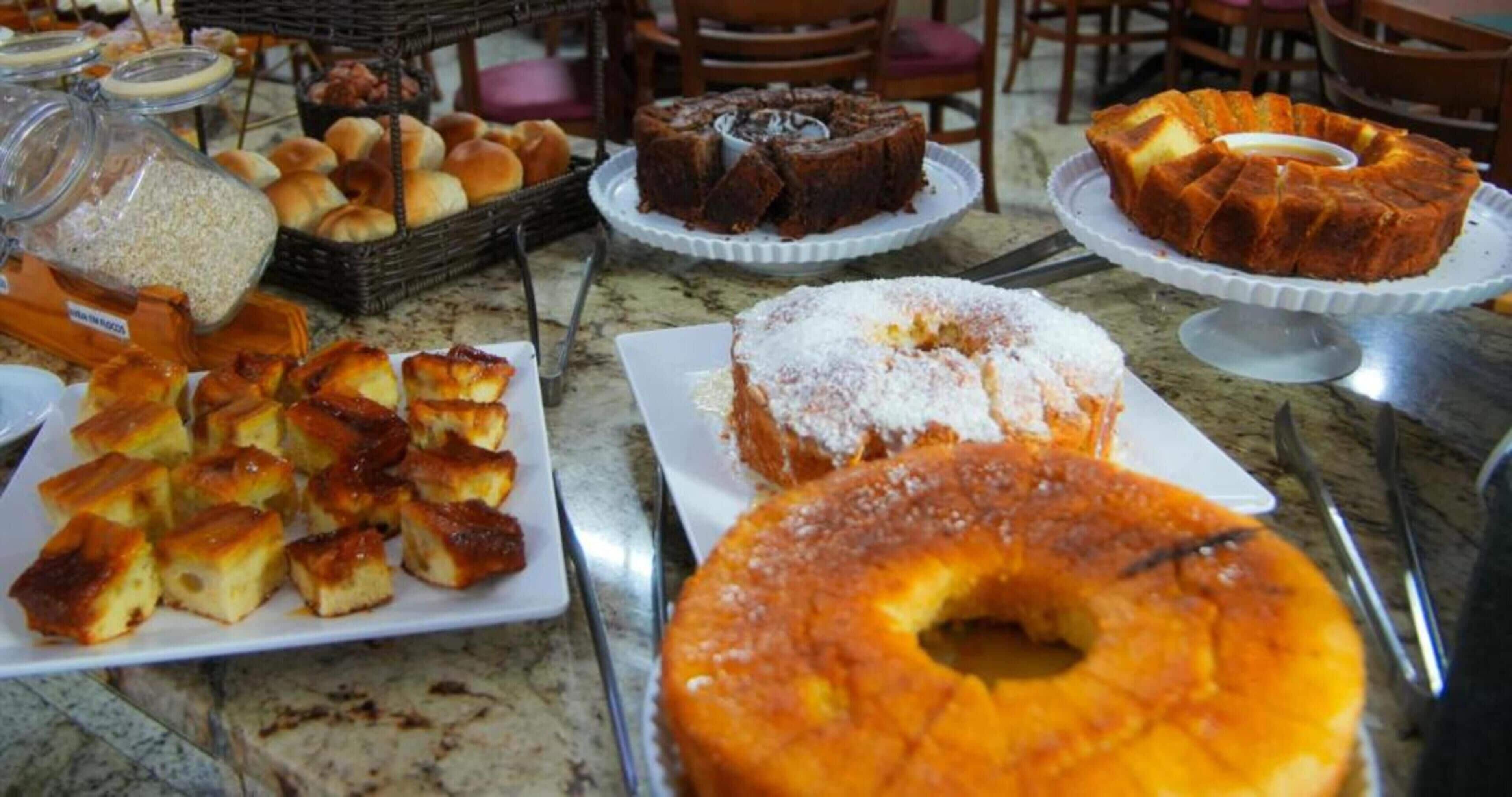 Una mesa de buffet con diversas opciones de panadería, incluyendo pasteles y repostería.