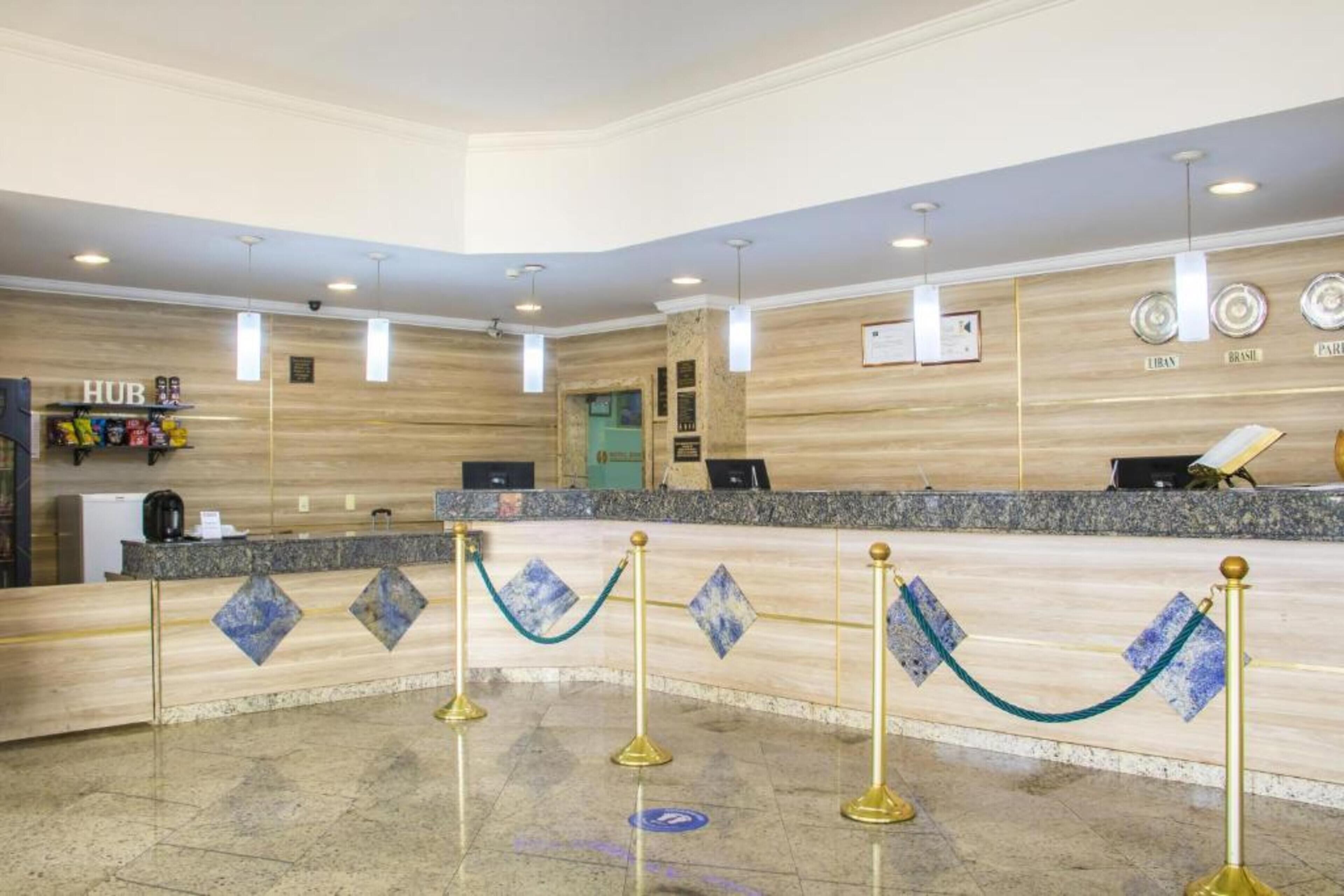 A hotel reception area with a counter, a coffee machine, and a sign labeled "HUB".