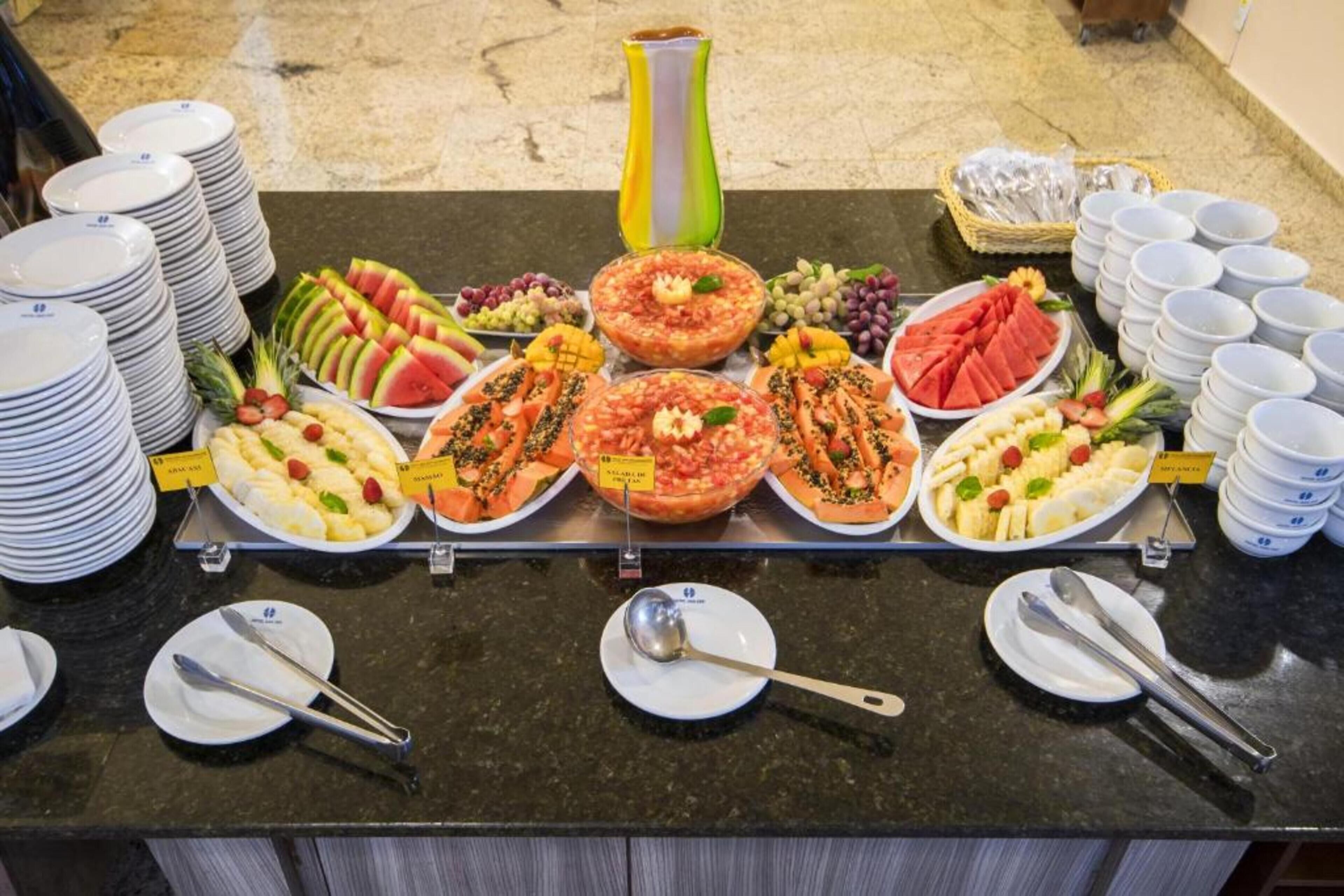Une table de buffet garnie de divers plats et surmontée d’un grand vase.