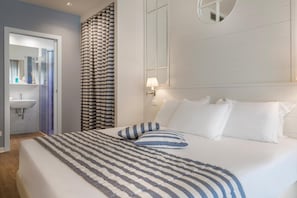 A hotel room with a bed, a bathroom with a sink, and a mirror. - Panorama (Cattolica)