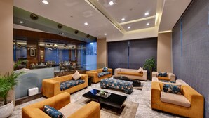 Un vestíbulo moderno con sofás, un mostrador de recepción y un comedor.