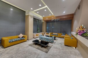 A modern lobby with sofas, a coffee table, and a reception desk.