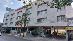 Un hotel de varios pisos, con un cartel que indica la entrada y un número de teléfono visible.