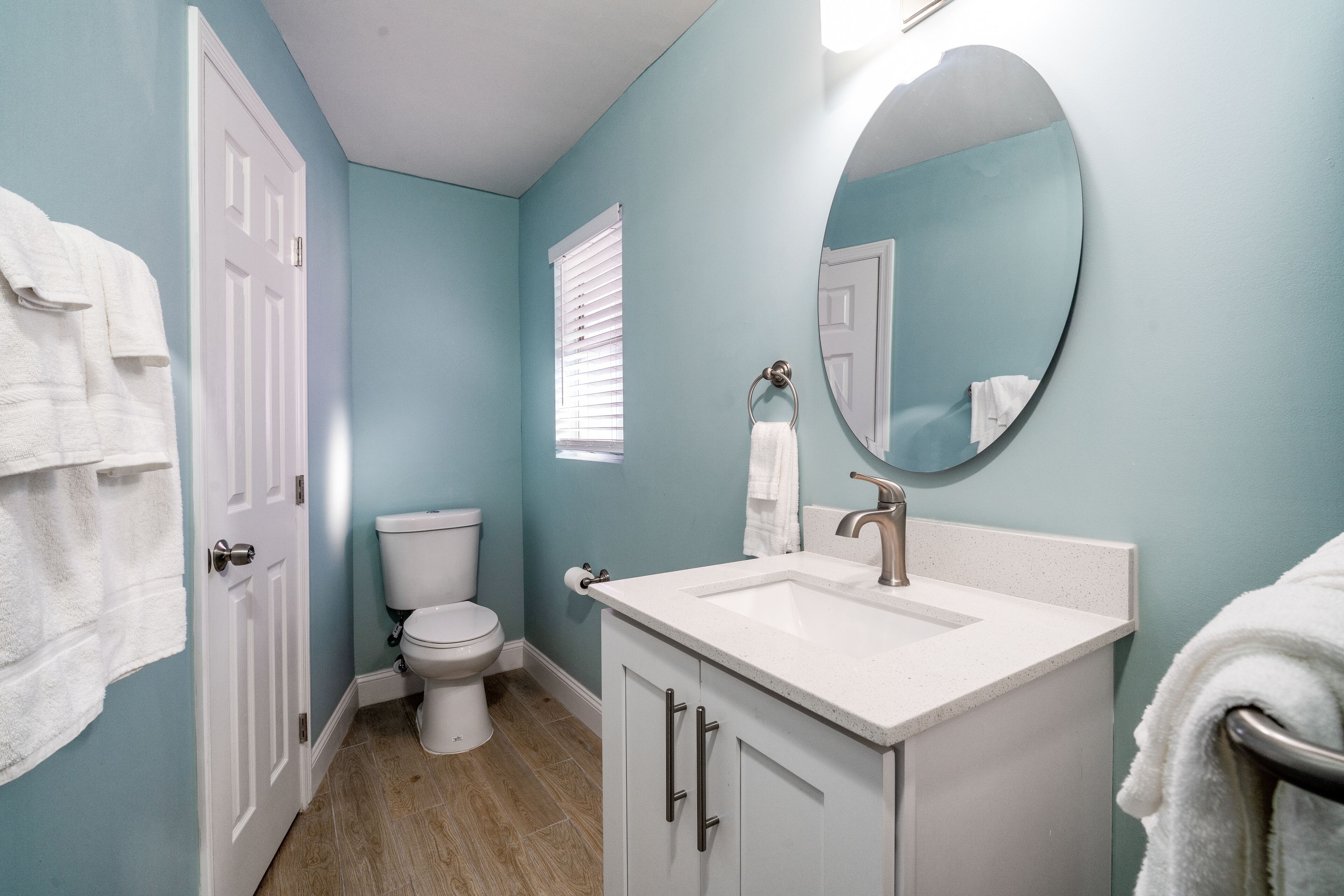 Une salle de bain avec des toilettes, un lavabo et un miroir.